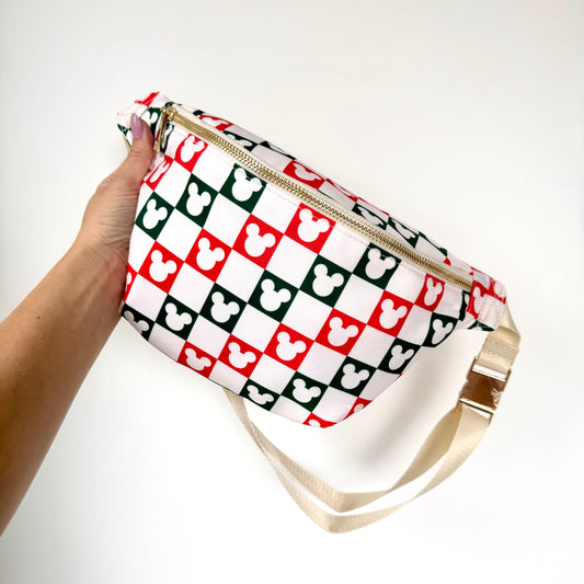 Pouch with red and green checkered pattern held by a hand on a white background