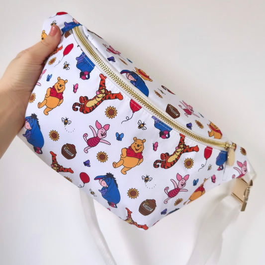 Crossbody bag with character print being held up on a white background