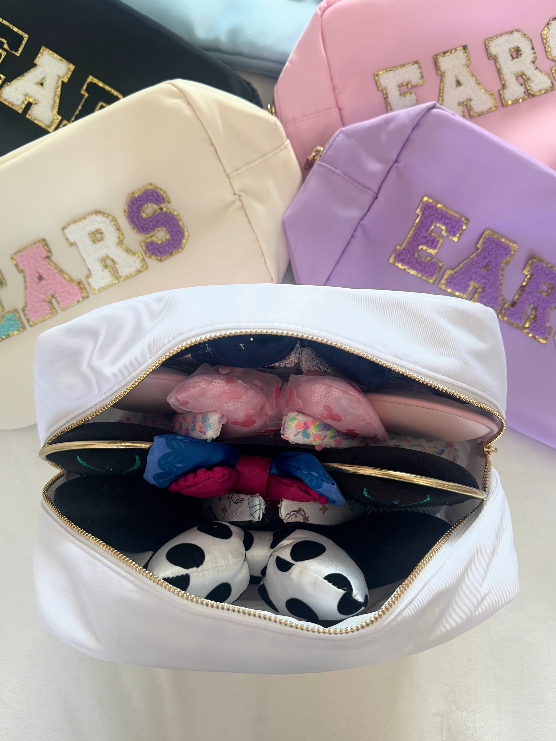 Colourful travel bags laid out together on a white background with one bag open