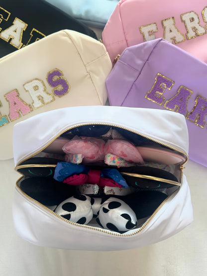 Colourful travel bags laid out together on a white background with one bag open